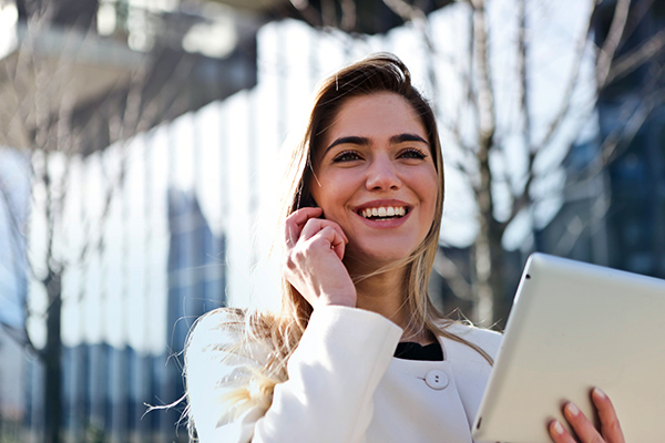 Student holding a tablet outdoors